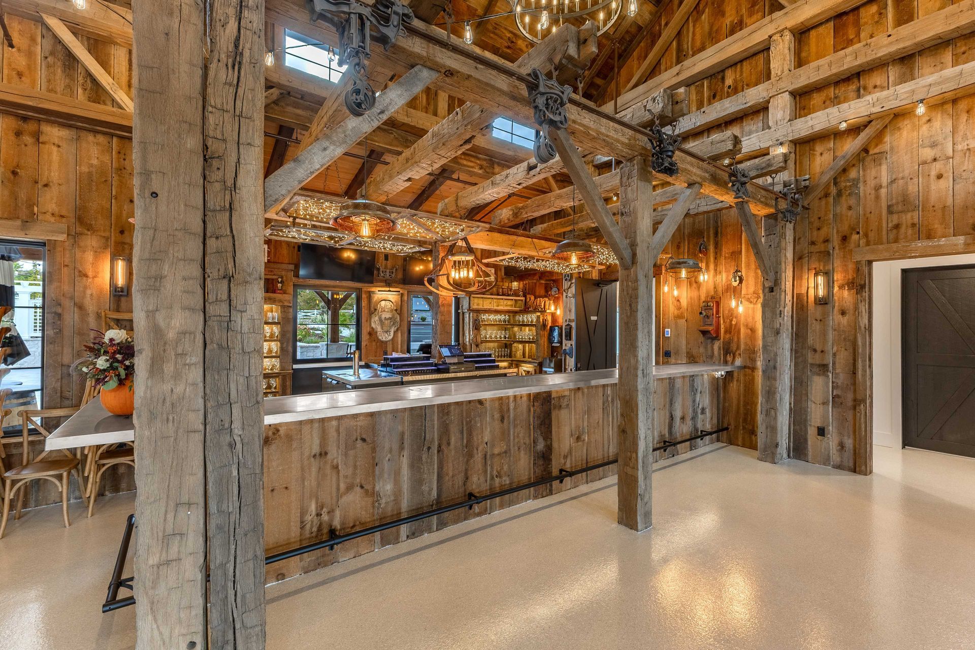 The inside of an old barn with wooden beams and a roof.