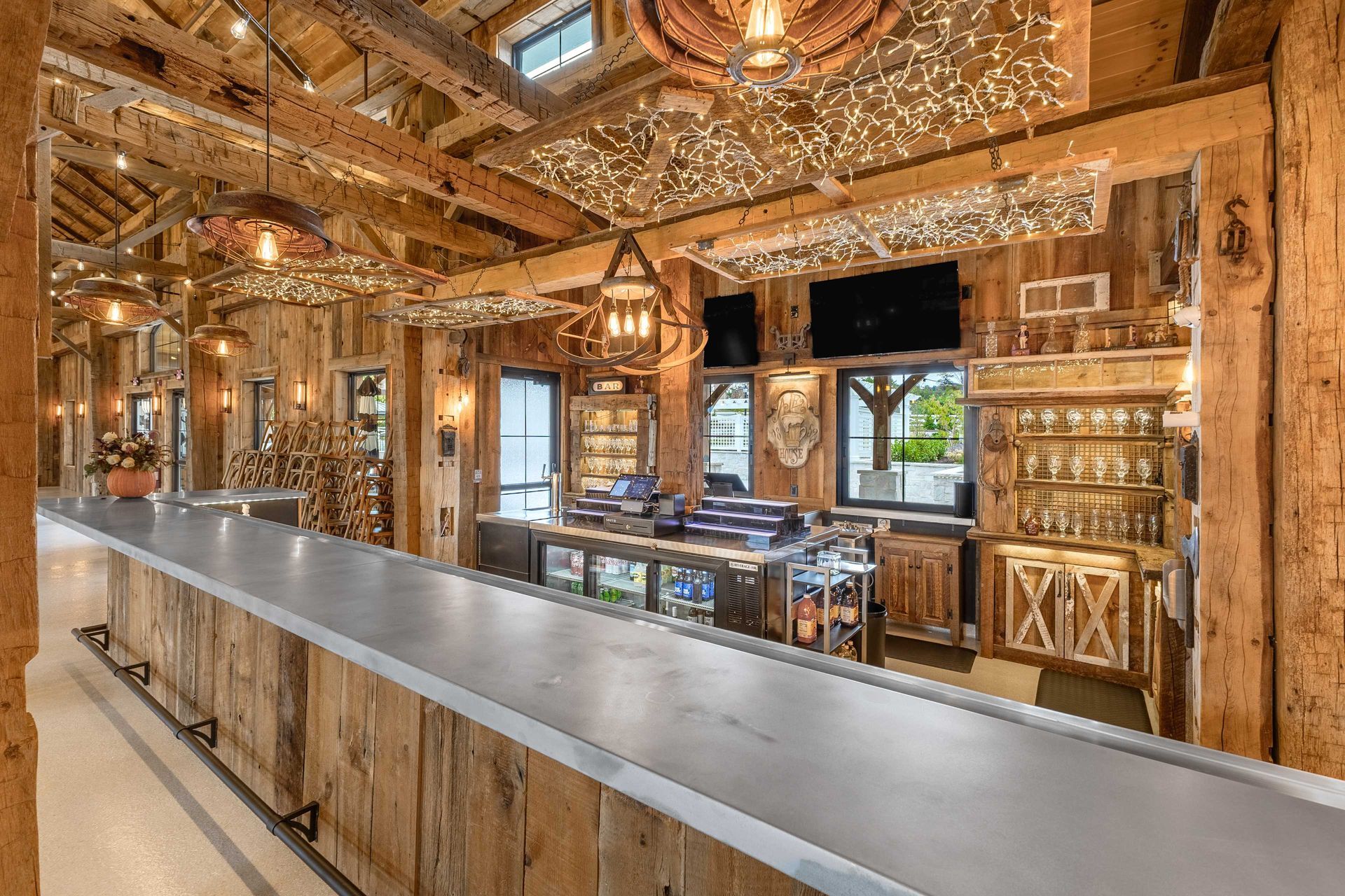 A rustic bar interior featuring reclaimed timber beams, a modern counter and decorative elements, demonstrating sustainable reclaimed timber uses.