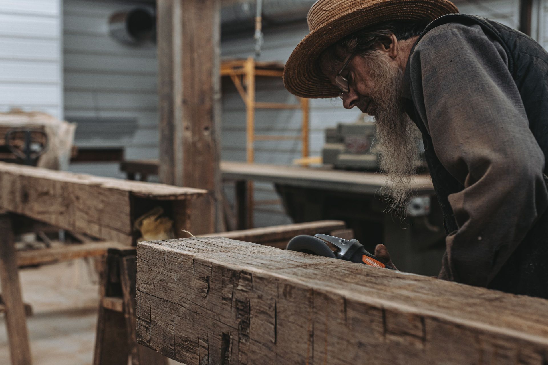 Man working on wooden beams for timber frame restoration.