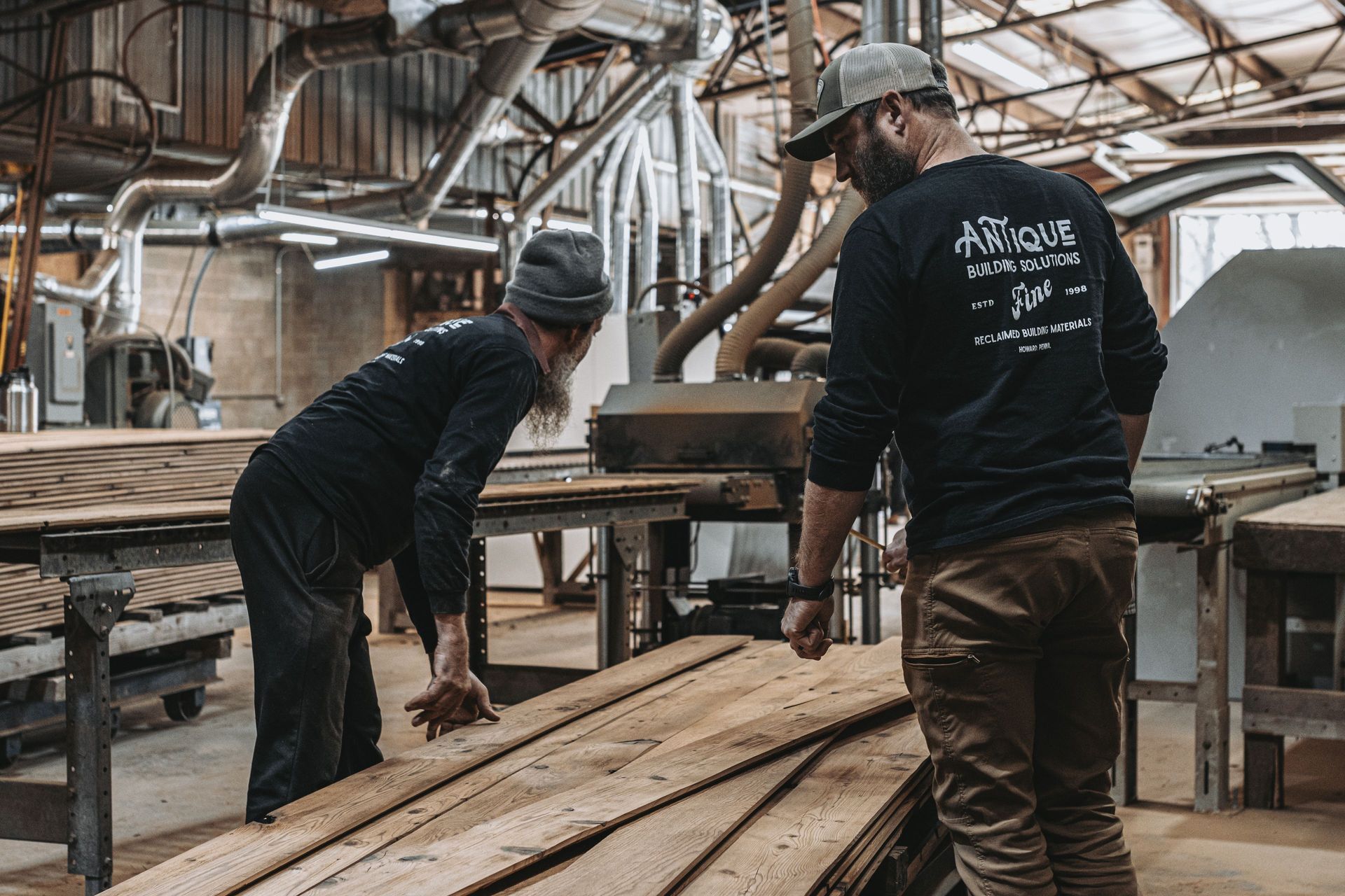 Craftsmen handling reclaimed wood for architectural preservation.