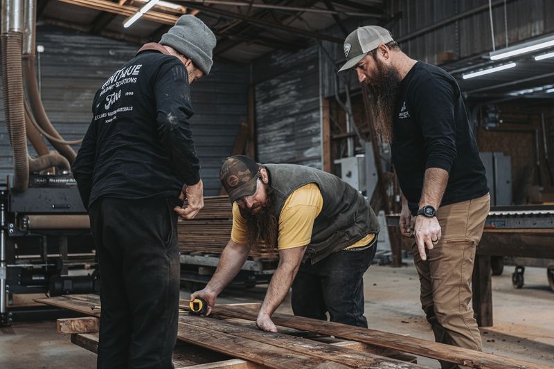 Team measuring wood for timber frame reassembly.