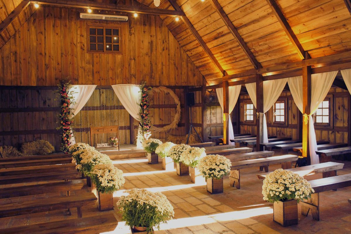 Rustic barn interior in Pennsylvania with aisle, benches, and floral arch for wedding conversions.