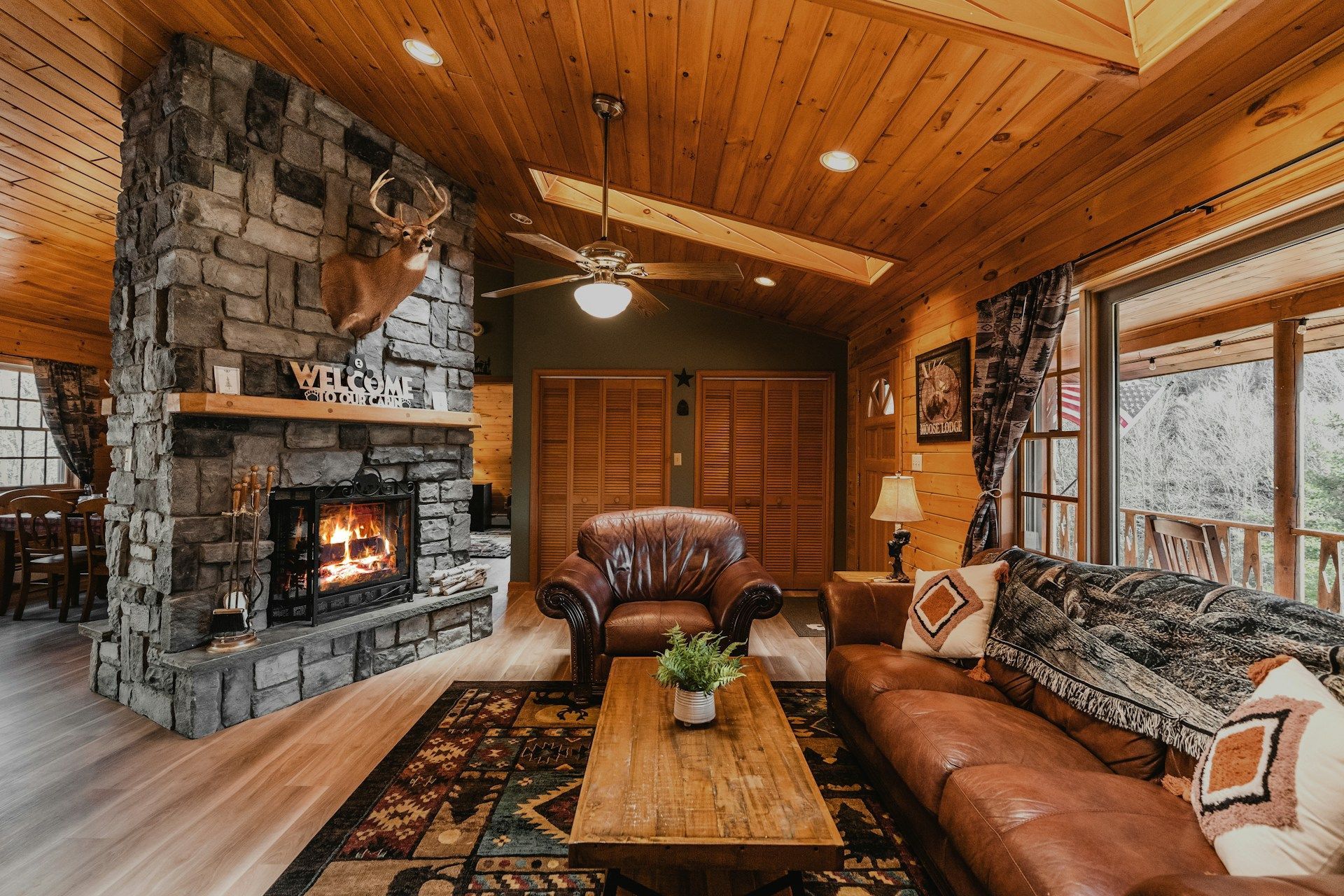 Cozy rustic living room with stone fireplace, showcasing barndominium kits' interior style.