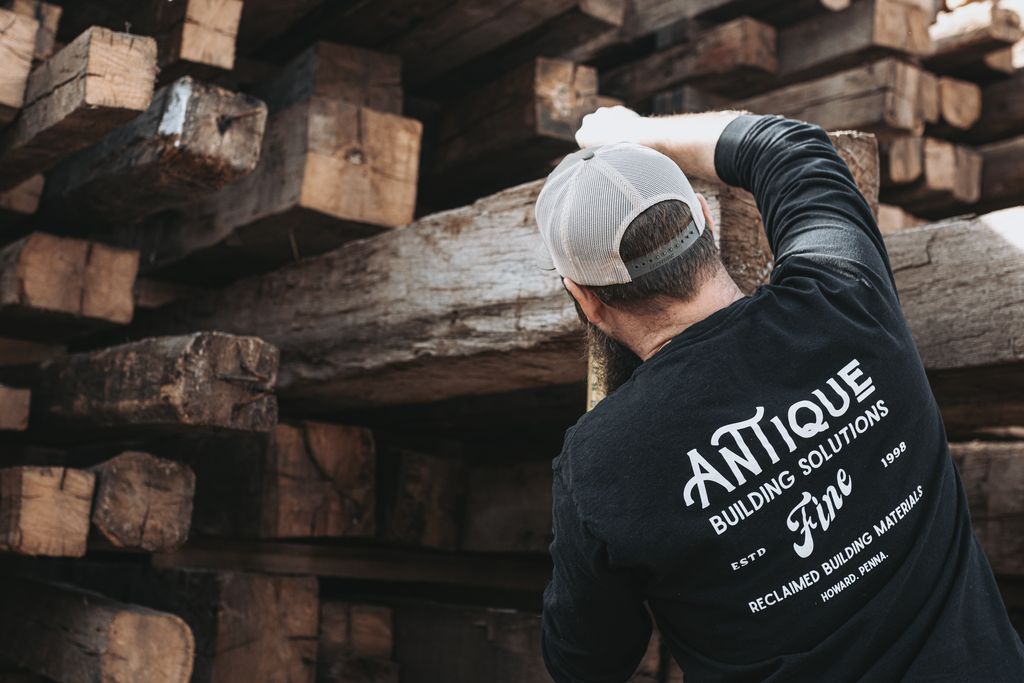 Craftsman Inspecting Reclaimed Wood for Use in Traditional Barns in Pennsylvania