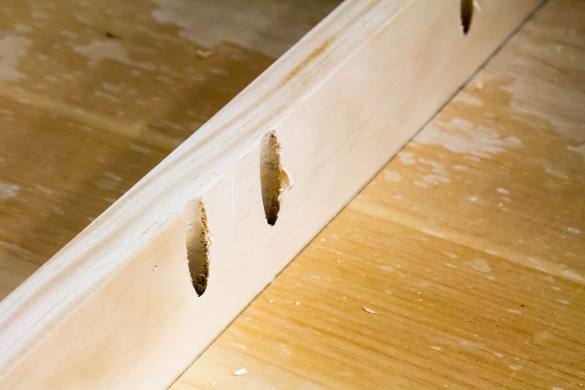 In Pennsylvania, wooden board features drilled holes and pocket screws for rustic joinery work.