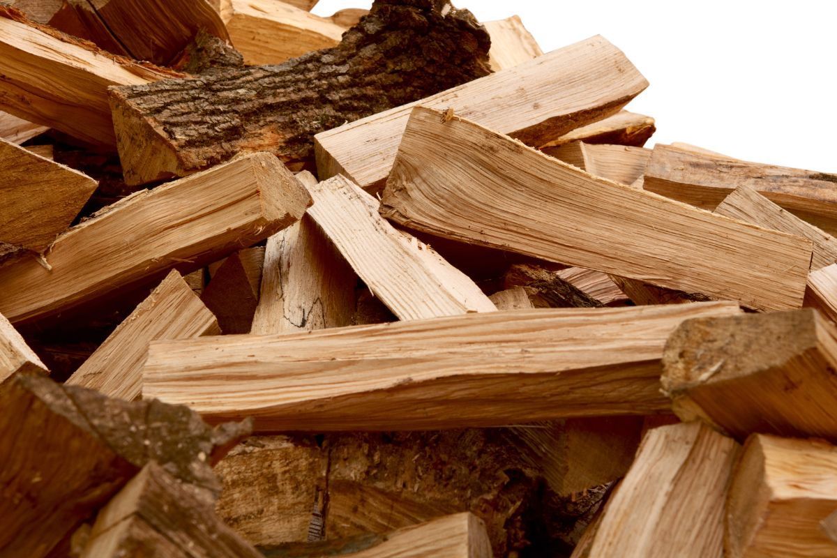 Pile of split firewood with brown and tan wood, ready for burning.