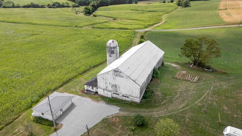 Historic barn homes with silo and rural fields.