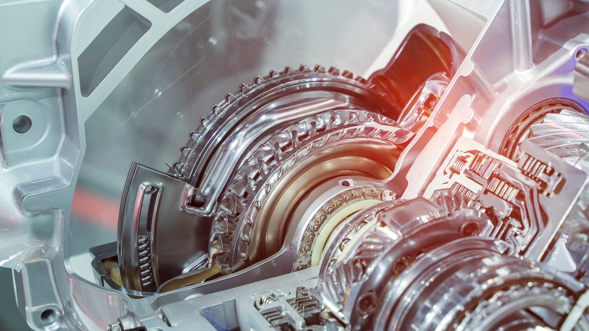A cross-section view of a metallic automotive transmission system, showing internal gears, clutches, and components.