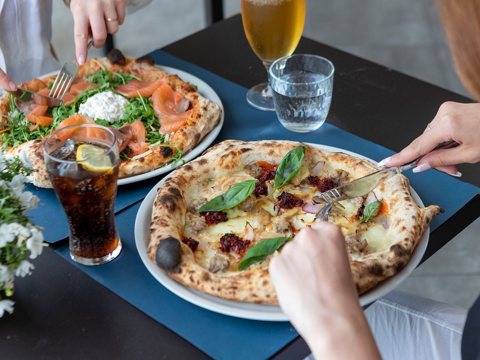 Due persone mangiano delle pizza a un tavolo.