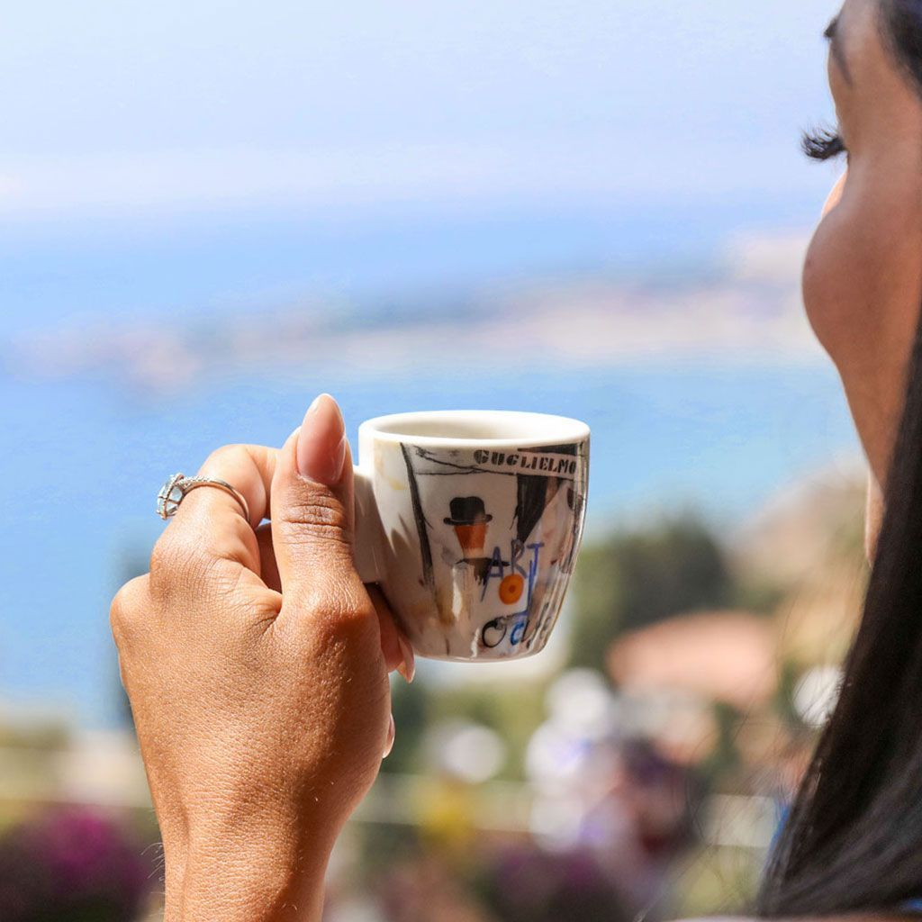 Donna con in mano una piccola tazza di caffè.