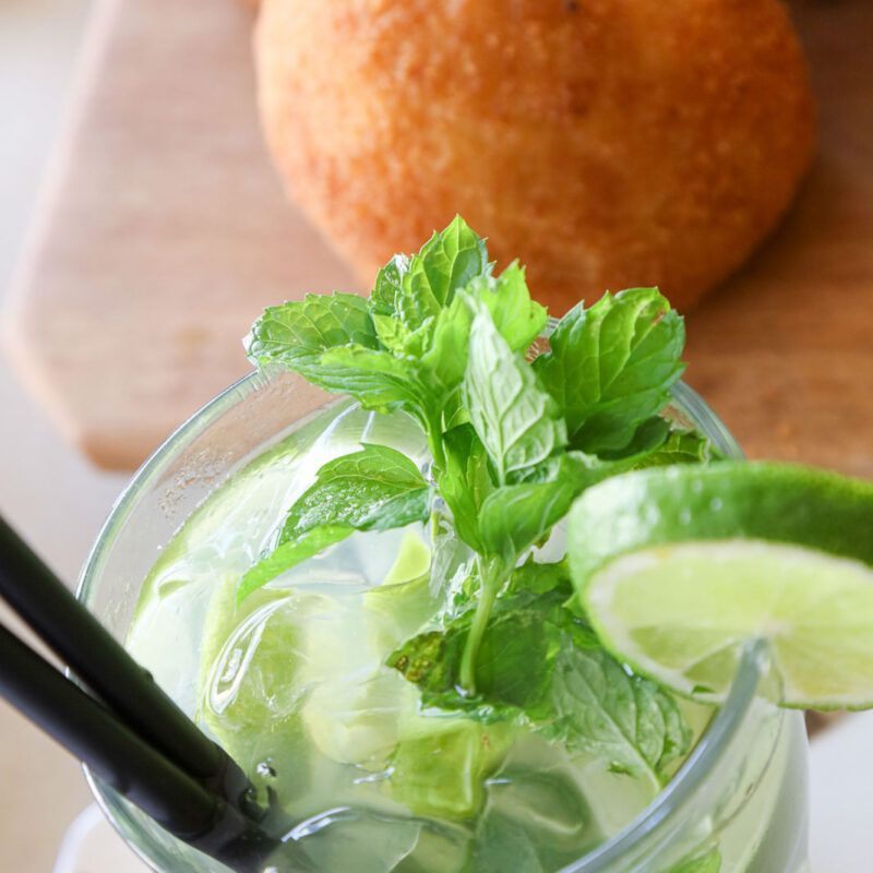 Cocktail Mojito con guarnizione di menta e fetta di lime.