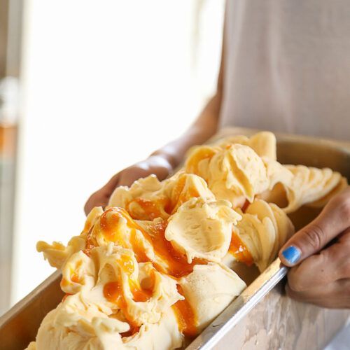 Persona che tiene in mano un vassoio di gelato giallo