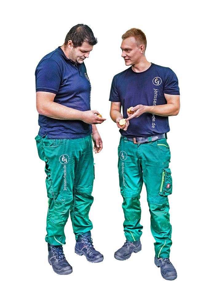 Drei Männer in grünen Hosen und blauen Hemden von Janssen GmbH & Co. KG Rhede/Ems stehen nebeneinander.