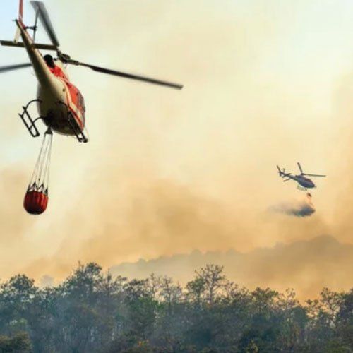 A helicopter is dropping water on a forest fire