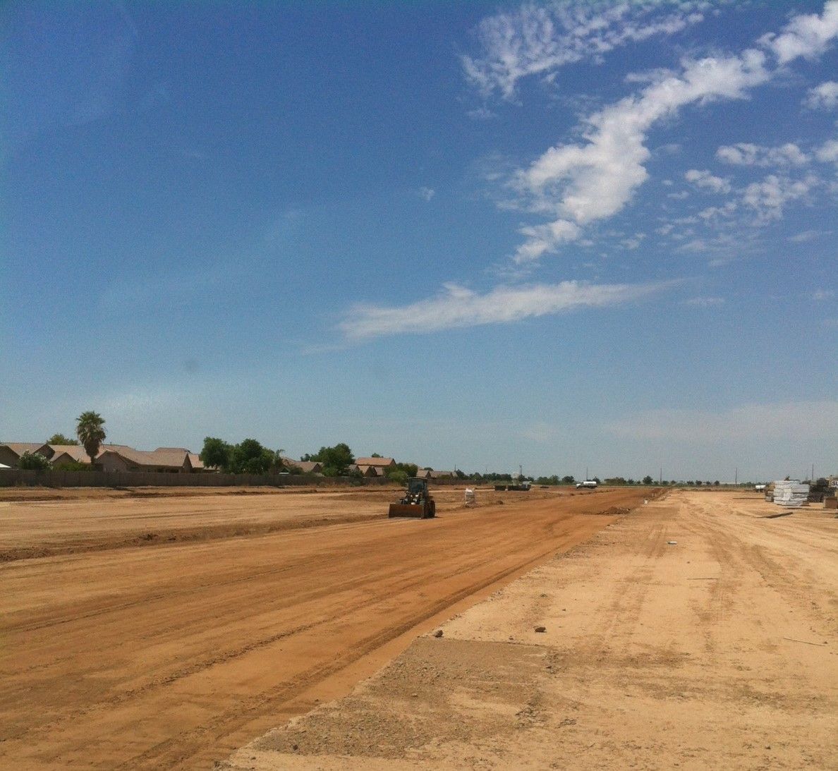 A dirt road with a blue sky in the background