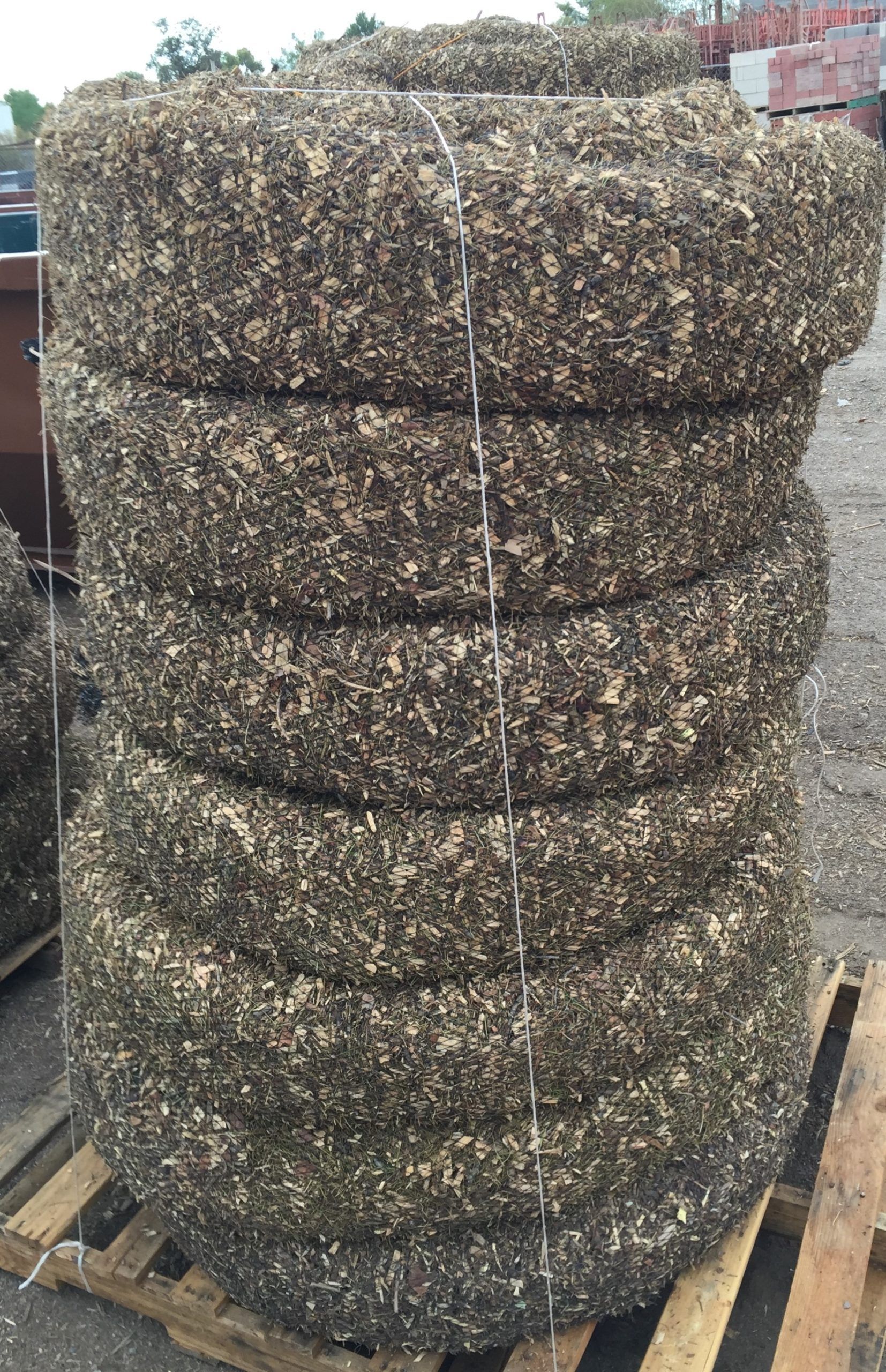 A stack of hay bales sitting on top of a wooden pallet.