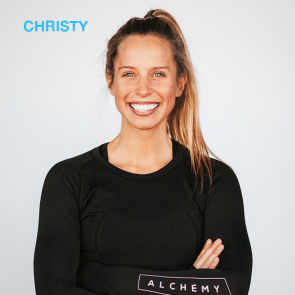 Christy, a smiling woman, wearing a black long-sleeved shirt with her arms crossed.