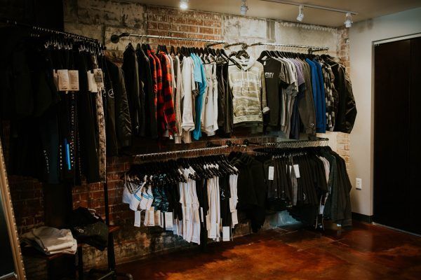 Clothing racks with various shirts and jackets inside a retail store.