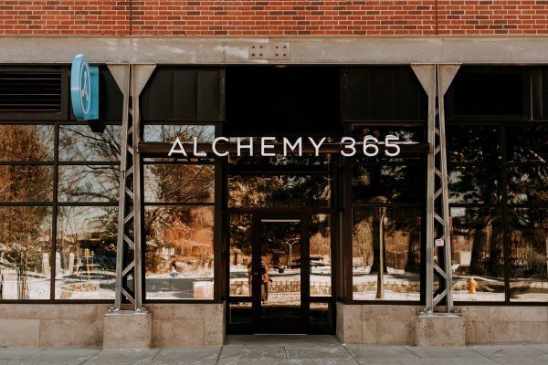 Exterior view of Alchemy 365 studio with large glass windows and the business name displayed above the entrance.