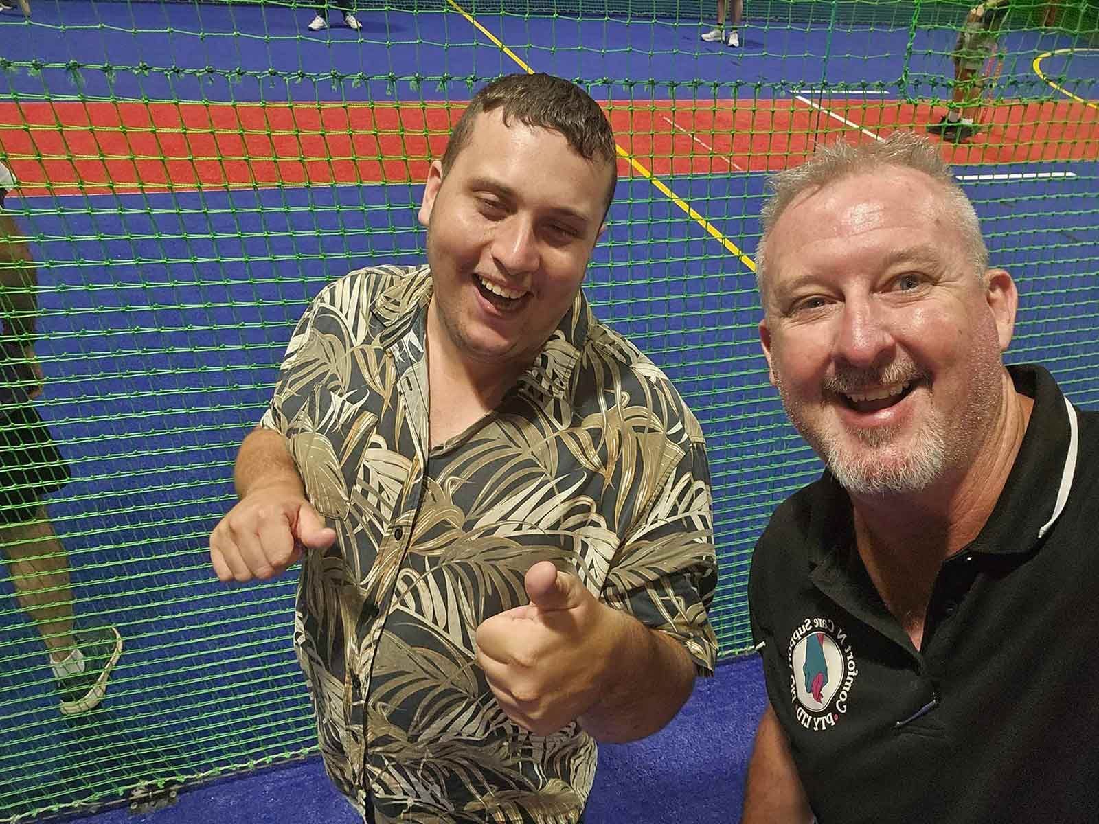Two Men Are Standing Next to Each Other  And Taking Selfie on A Tennis Court — Comfort N Care Support QLD Pty Ltd In Toowoomba City, QLD