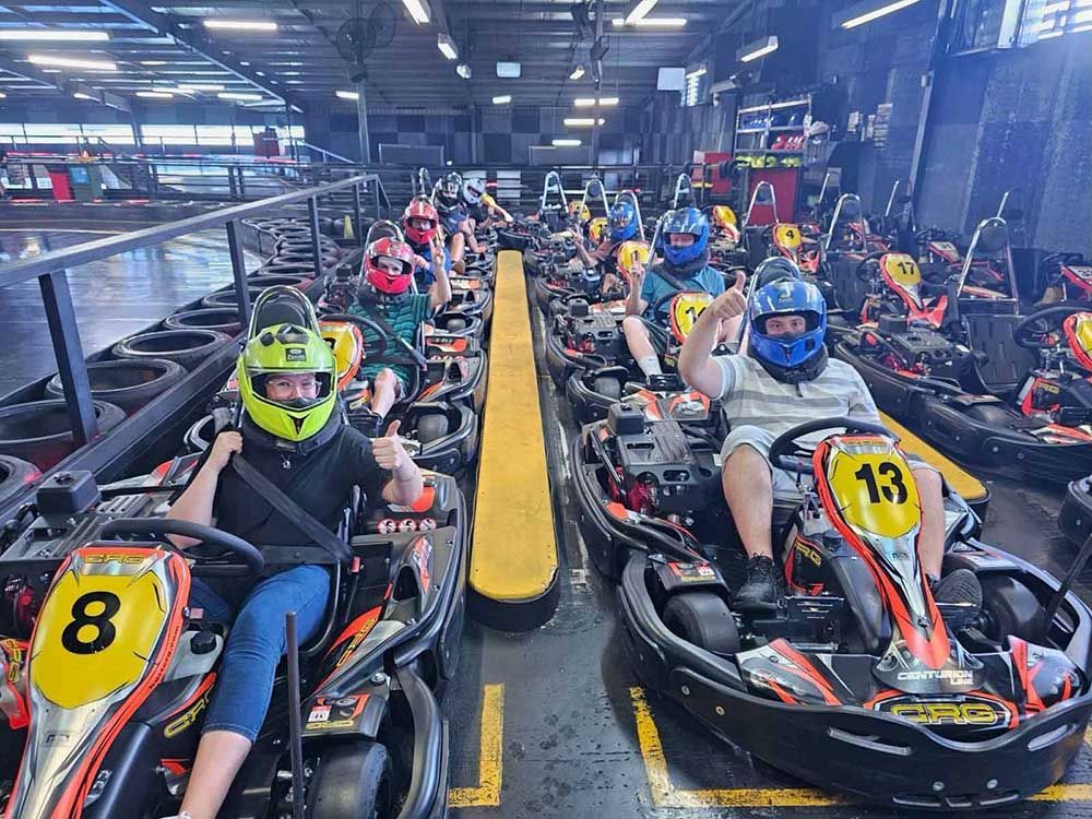 A Group of People Are Riding Go Karts on A Track — Comfort N Care Support QLD Pty Ltd In Toowoomba City, QLD