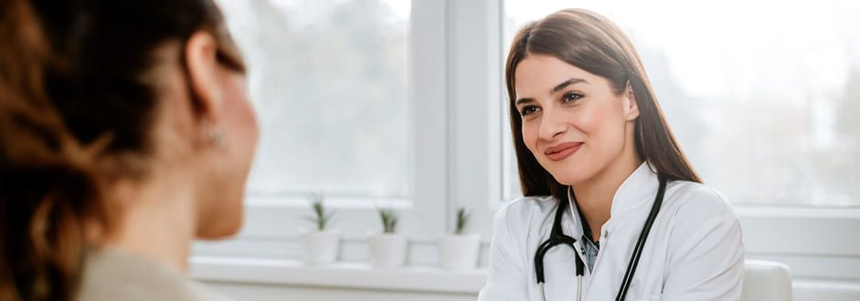 Uma médica está conversando com um paciente em um hospital.