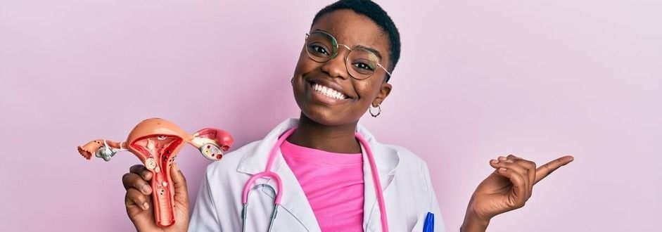 Exame de Papanicolau, jovem médica segurando um modelo do órgão genital feminino