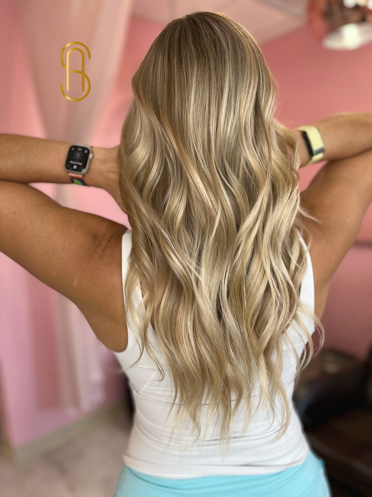 A woman with long blonde hair is wearing an apple watch.