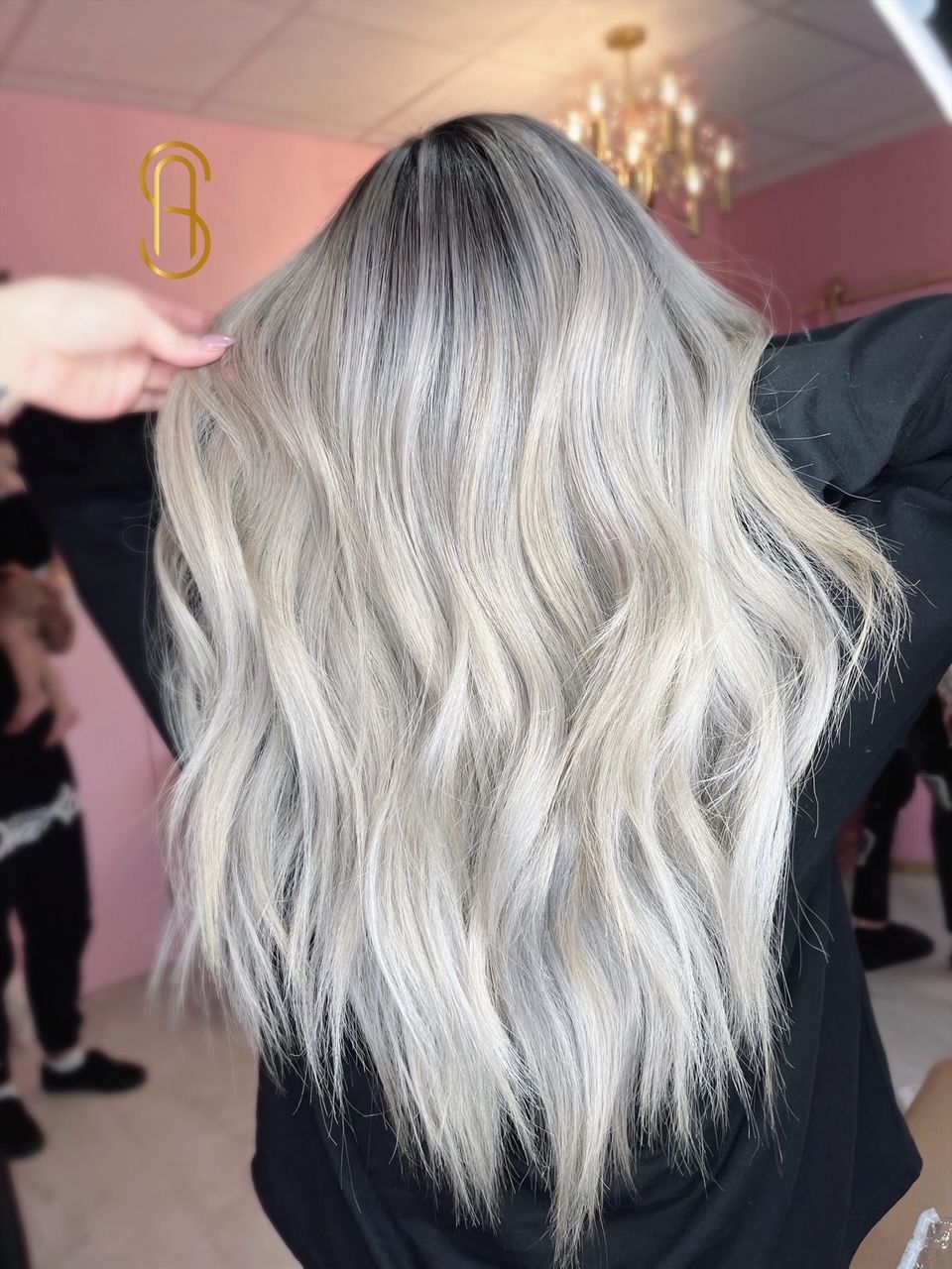 A woman with long blonde hair is standing in front of a mirror.