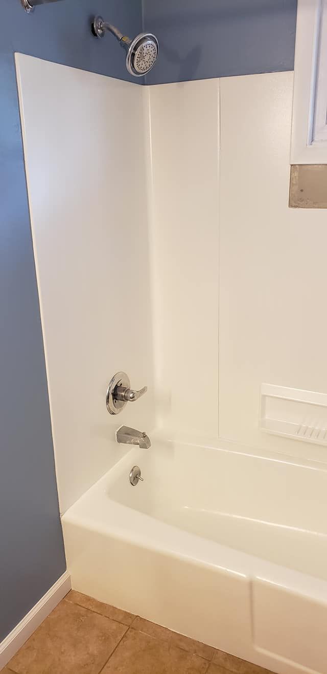 A bathroom with a bathtub , shower , and blue walls.