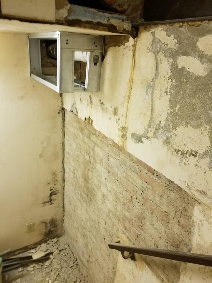 A room with a staircase and a brick wall