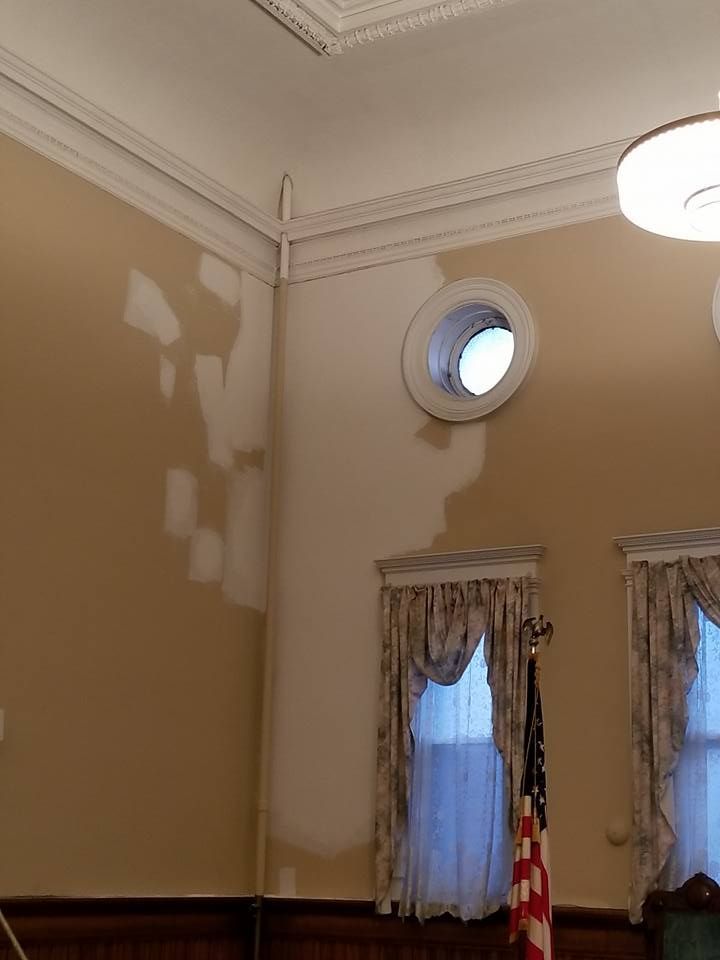 A room with two windows and a ceiling light