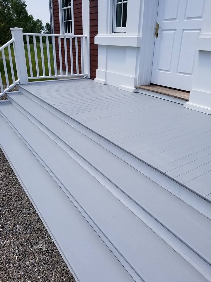 A white house with a white railing and stairs