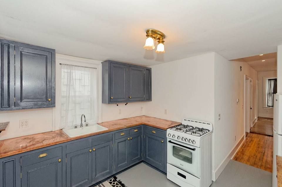 A kitchen with gray cabinets and a white stove