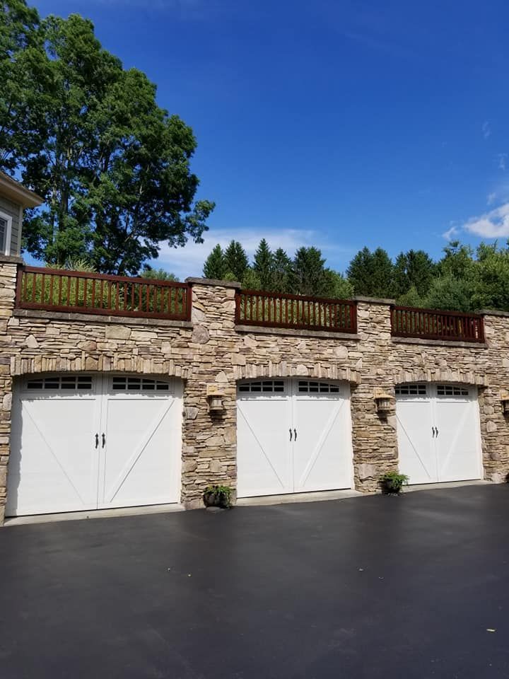 A row of white garage doors on a stone building