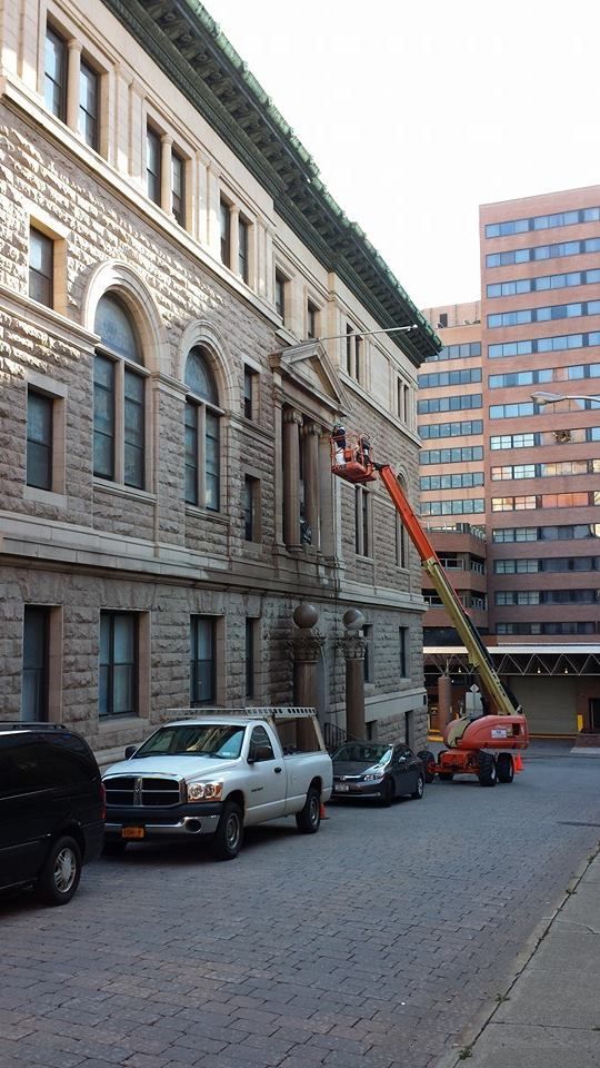 A white truck is parked in front of a large building