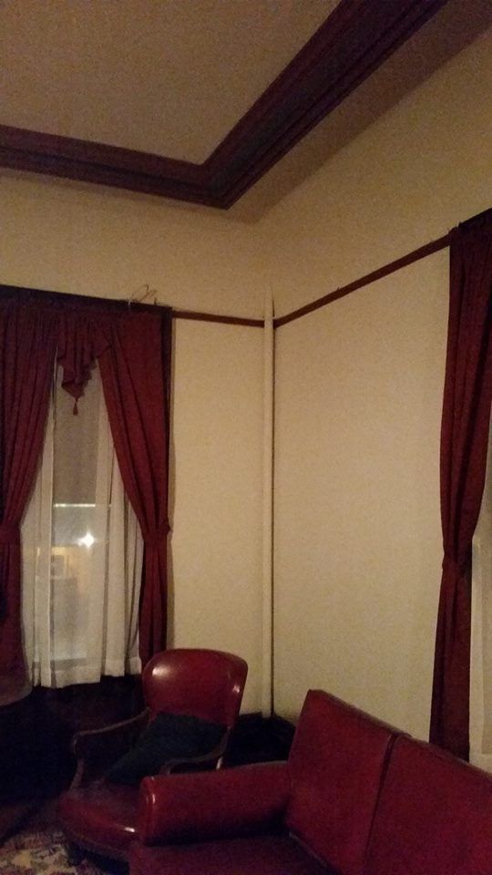 A living room with a red couch , chair , and window.