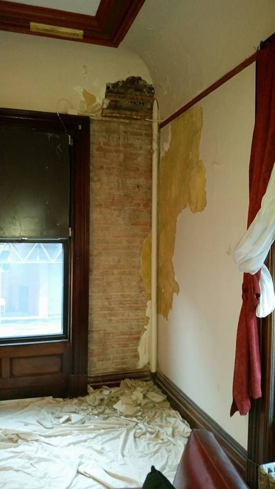 A room with a brick wall and a window.