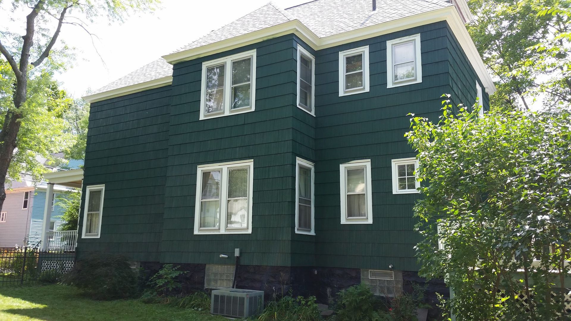 A green house with white windows and a white roof