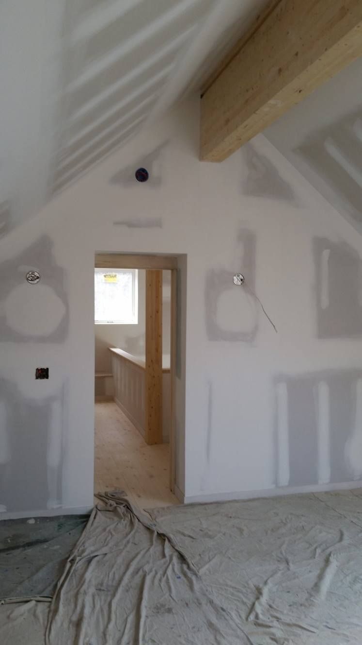 A room with a vaulted ceiling and a doorway leading to a bathroom.