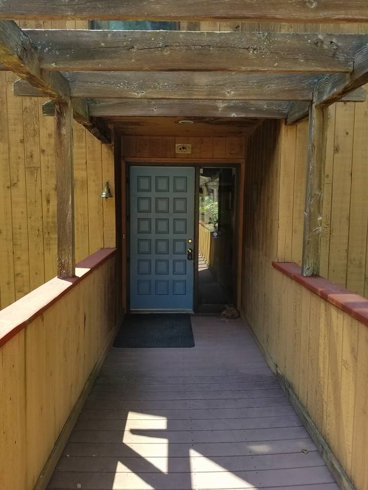 A wooden walkway leading to a blue door
