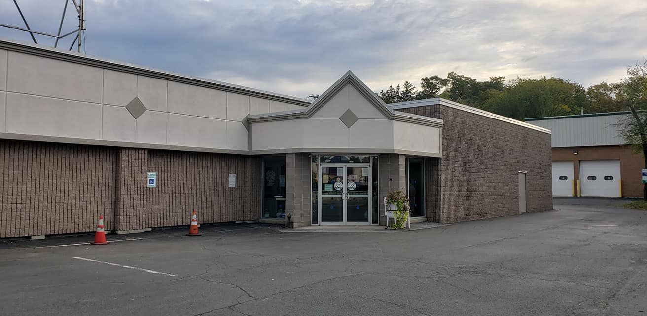 A large brick building with a parking lot in front of it.