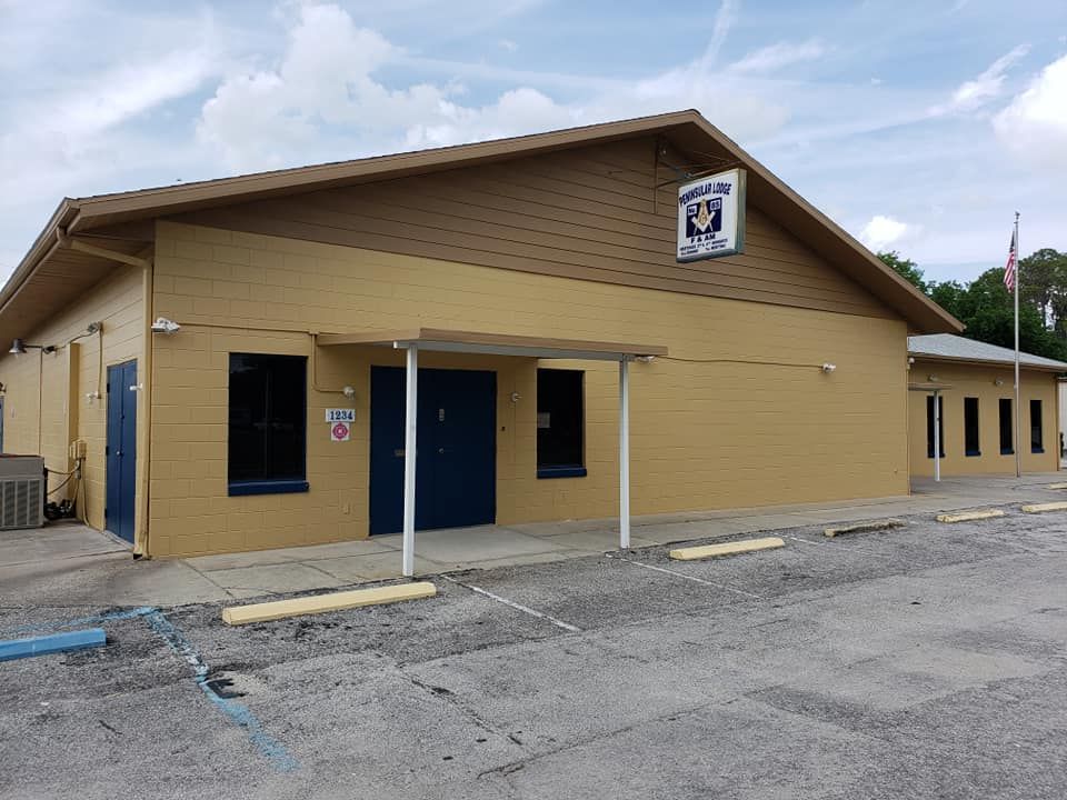 A yellow building with a blue door and a sign that says " no parking "