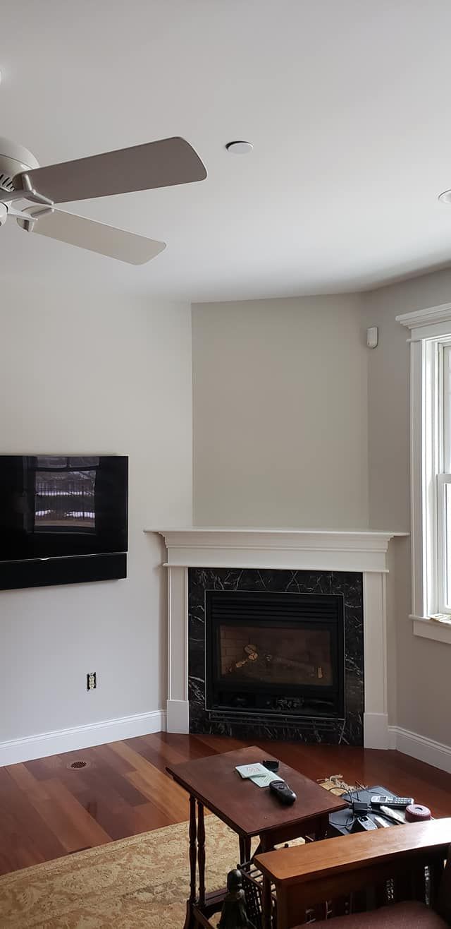 A living room with a fireplace and a ceiling fan
