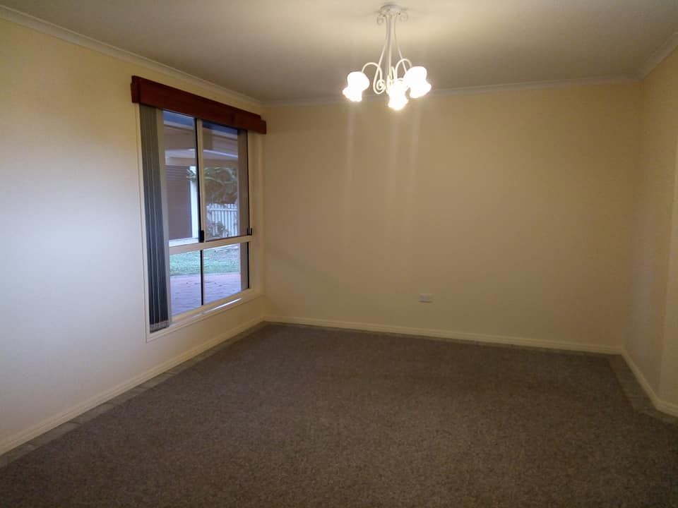 An Empty Living Room with A Chandelier and A Large Window — Your Local Handywoman in Burnett Heads, QLD