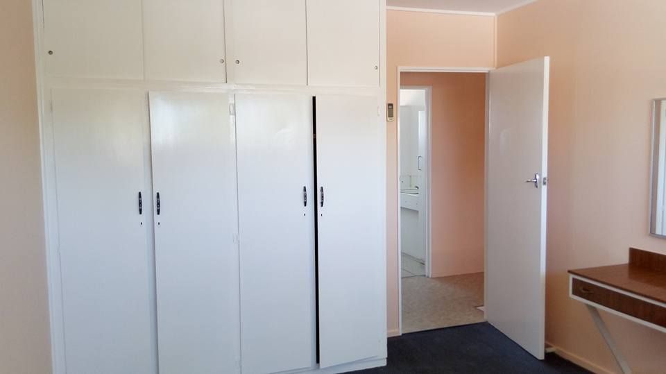A Bedroom with White Cabinets, a Dresser and A Mirror — Your Local Handywoman in Burnett Heads, QLD