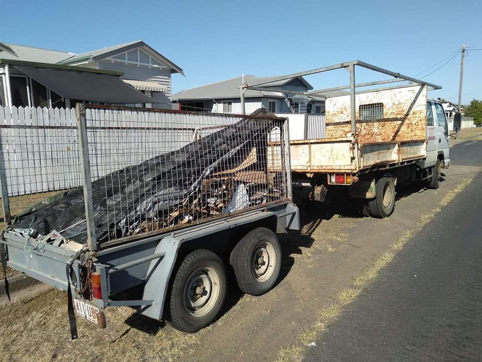 A Truck with A Trailer Attached to It Is Parked on The Side of The Road — Your Local Handywoman in Burnett Heads, QLD