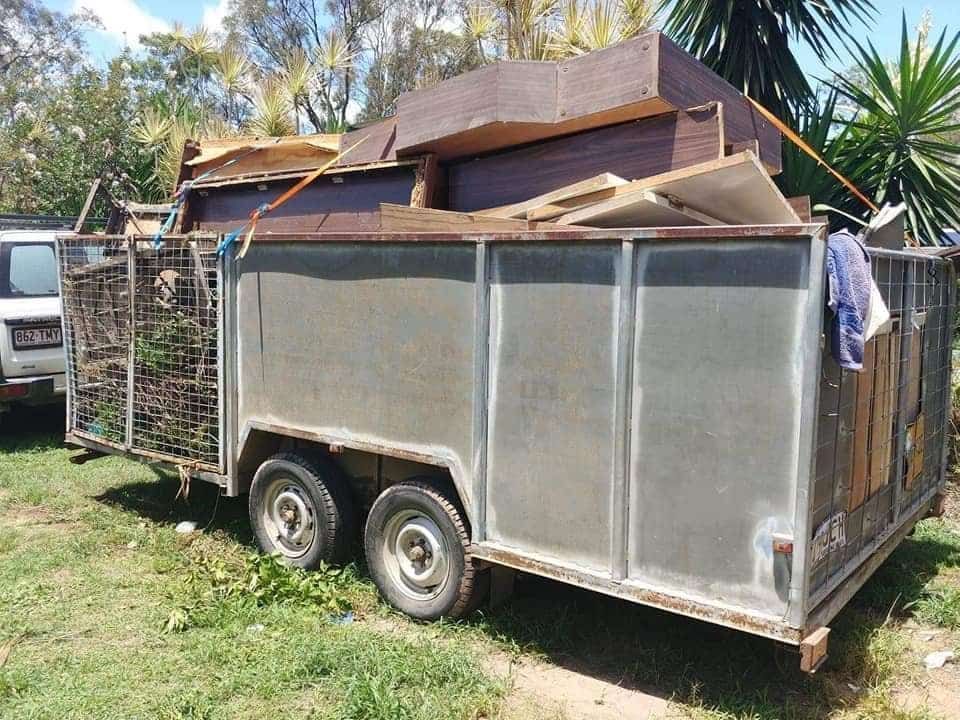 A Trailer Filled with Junk Is Parked in The Grass — Your Local Handywoman in Burnett Heads, QLD