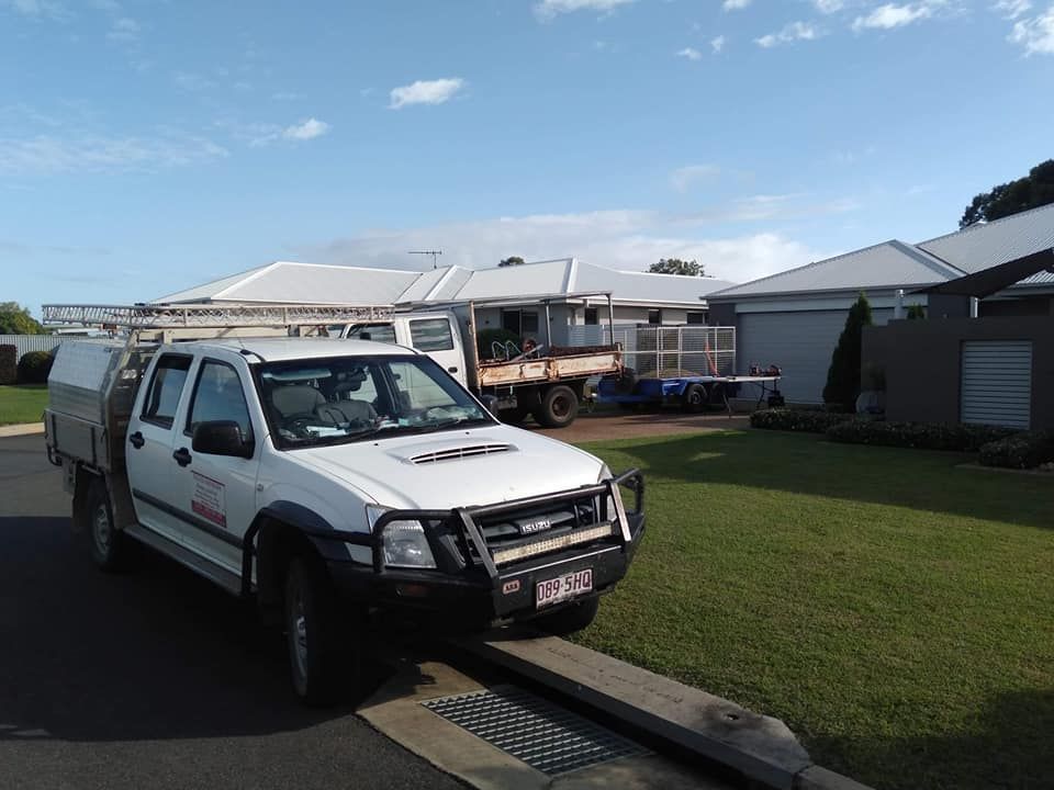 A White Truck Is Parked on The Side of The Road in Front of A House — Your Local Handywoman in Burnett Heads, QLD