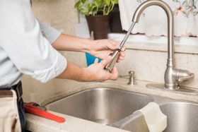 professional plumber installing kitchen sink facet